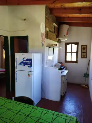 a kitchen with a white refrigerator in a room at Panaholma resort Cabañas de montaña in Panaholma