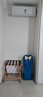 a bench with a backpack sitting next to a refrigerator at La Paz 80 in Villa Carlos Paz