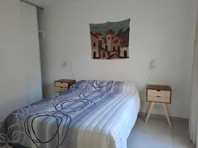 a bedroom with a bed and a painting on the wall at La Paz 80 in Villa Carlos Paz