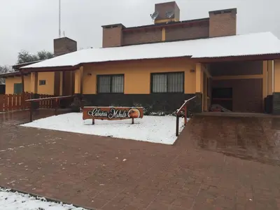 a sign in the snow in front of a building at Cabañas MAHALO in Villa Rumipal