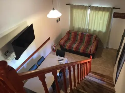 a living room with a couch and a table at Cabañas MAHALO in Villa Rumipal