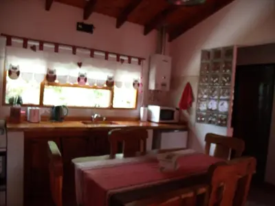 a kitchen with a table and a sink and a window at Cabañas de Colores in Los Reartes