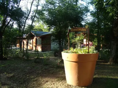 a large flower pot with a sign that says bathrooms at Cabañas de Colores in Los Reartes