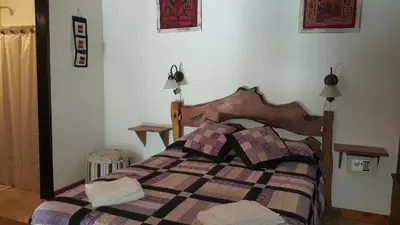 a bedroom with a bed with a checkered blanket at Cabañas de Colores in Los Reartes