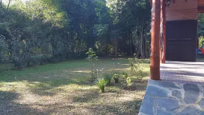 a porch of a house with a yard with trees at Cabañas de Colores in Los Reartes