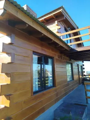 a house with a wall of wood at Cabaña de quebracho de dos pisos in Villa General Belgrano