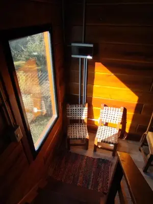an attic room with two chairs and a window at Cabaña de quebracho de dos pisos in Villa General Belgrano