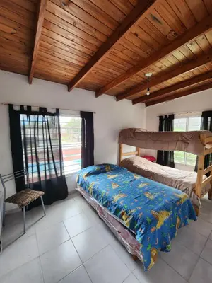 a bedroom with two beds and a wooden ceiling at Altos de Grecia Cabaña 3 in Villa Carlos Paz