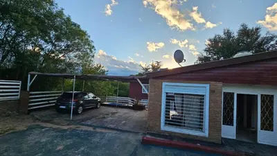 a car parked in a garage next to a house at Altos de Grecia Cabaña 3 in Villa Carlos Paz