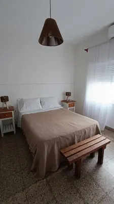 a bedroom with a large bed and a bench at Departamento interno in Alta Gracia