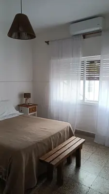 a bedroom with a bed and a wooden bench at Departamento interno in Alta Gracia