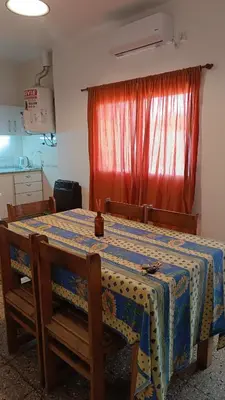 a table in a kitchen with a red curtain at Departamento interno in Alta Gracia