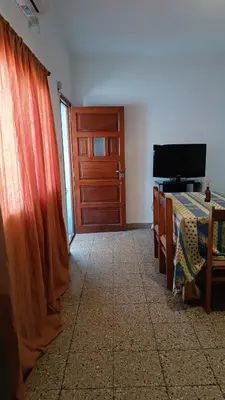a room with a door and a bed and a television at Departamento interno in Alta Gracia