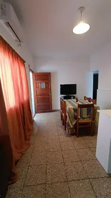 a living room with a table and a red curtain at Departamento interno in Alta Gracia