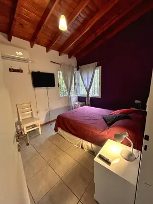 a bedroom with a bed and a desk and a tv at Departamento Cerro Overo in Merlo