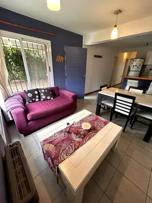 a living room with a purple couch and a table at Departamento Cerro Overo in Merlo
