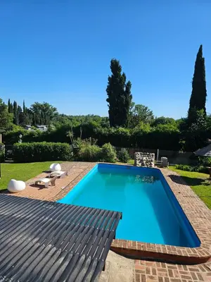 a swimming pool in a yard with a patio at Departamento con pileta cerca del centro in Villa General Belgrano