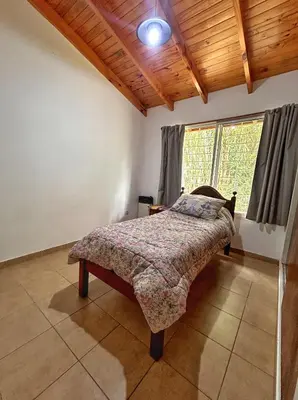 a bedroom with a bed in a room with a window at Casa Longoseiros in Merlo