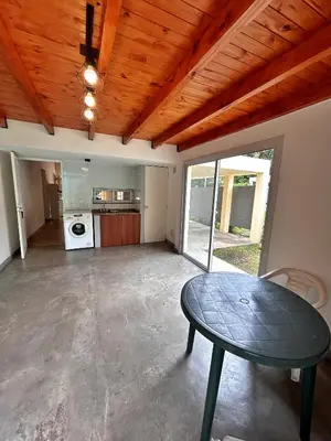 a living room with a table and a kitchen at Casa Longoseiros in Merlo