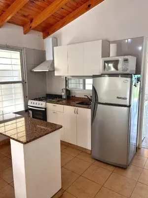 a kitchen with a stainless steel refrigerator and white cabinets at Casa Longoseiros in Merlo