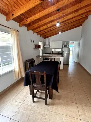 a dining room with a table and a kitchen at Casa Longoseiros in Merlo