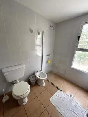 a white bathroom with a toilet and a sink at Casa Longoseiros in Merlo