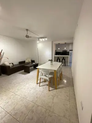 a living room with a white table and a couch at Torre Kalinka dos dormitorios pleno centro in Villa Carlos Paz
