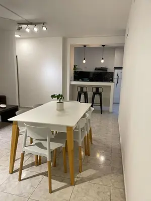 a dining room with a white table and chairs at Torre Kalinka dos dormitorios pleno centro in Villa Carlos Paz