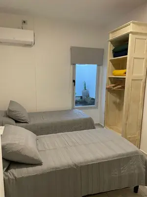 two beds in a room with a window at Torre Kalinka dos dormitorios pleno centro in Villa Carlos Paz