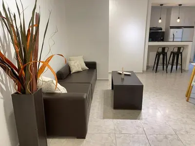 a living room with a black couch and a table at Torre Kalinka dos dormitorios pleno centro in Villa Carlos Paz