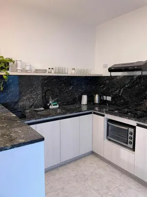 a kitchen with black granite counter tops and a sink at Torre Kalinka dos dormitorios pleno centro in Villa Carlos Paz