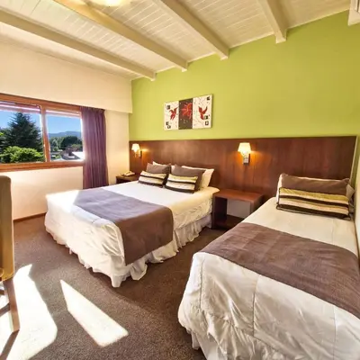 a hotel room with two beds and a window at Berna Hotel & Spa in Villa General Belgrano