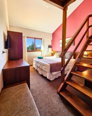 a hotel room with a bed and a staircase at Berna Hotel & Spa in Villa General Belgrano
