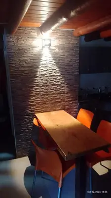 a room with a wooden table and orange chairs at Posada del Arroyo in Las Rabonas