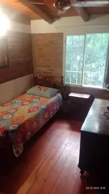 a bedroom with a bed and a desk in it at Posada del Arroyo in Las Rabonas