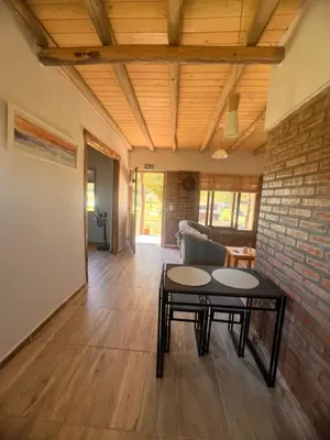 a living room with a table and a brick wall at Ranchos de la Tata in Las Calles
