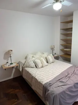 a white bedroom with a bed with pillows at Departamento en Nueva Cordoba in Cordoba