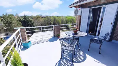 a patio with a table and chairs on a deck at Viento Sur in Villa General Belgrano