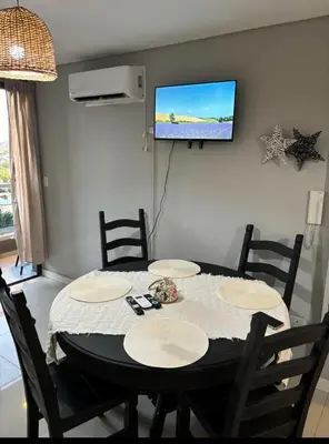 a dining room with a table and a tv on a wall at Departamento en general Paz a pocas cuadras del panal in Cordoba