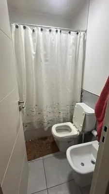 a bathroom with a toilet and a white shower curtain at Departamento en general Paz a pocas cuadras del panal in Cordoba