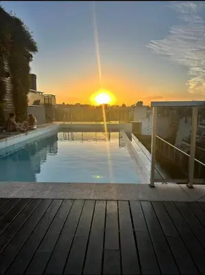 a swimming pool with the sunset in the background at Departamento en general Paz a pocas cuadras del panal in Cordoba