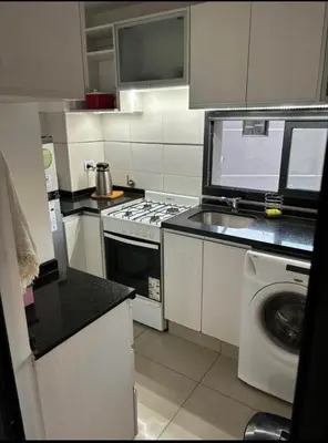a kitchen with a stove and a washing machine at Departamento en general Paz a pocas cuadras del panal in Cordoba