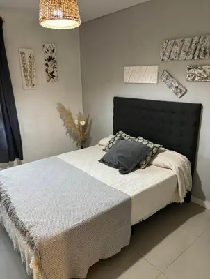 a bedroom with a bed with a gray pillow on it at Departamento en general Paz a pocas cuadras del panal in Cordoba