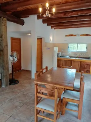 a dining room with a wooden table and chairs at CABAÑA PRIVADA NALÚ 2, Villa Ciudad Parque a 150m Río Los Reartes in Villa Ciudad Parque