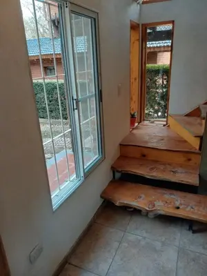 a room with a staircase and a window at CABAÑA PRIVADA NALÚ 2, Villa Ciudad Parque a 150m Río Los Reartes in Villa Ciudad Parque