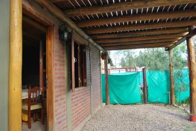 an outside view of a house with a wooden roof at TIERRA SERRANA CABAÑAS s in Villa Anizacate