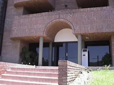 a brick building with an arch in front of it at Confortable Carlos Paz Céntrico 4 personas Estac Interno in Villa Carlos Paz