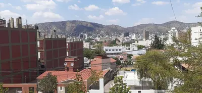 a view of a city with mountains in the background at Confortable Carlos Paz Céntrico 4 personas Estac Interno in Villa Carlos Paz