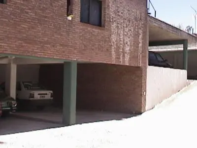 a brick garage with a car parked in it at Confortable Carlos Paz Céntrico 4 personas Estac Interno in Villa Carlos Paz