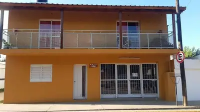 a yellow house with a balcony on top of it at Monoambiente NONA in Villa Cura Brochero